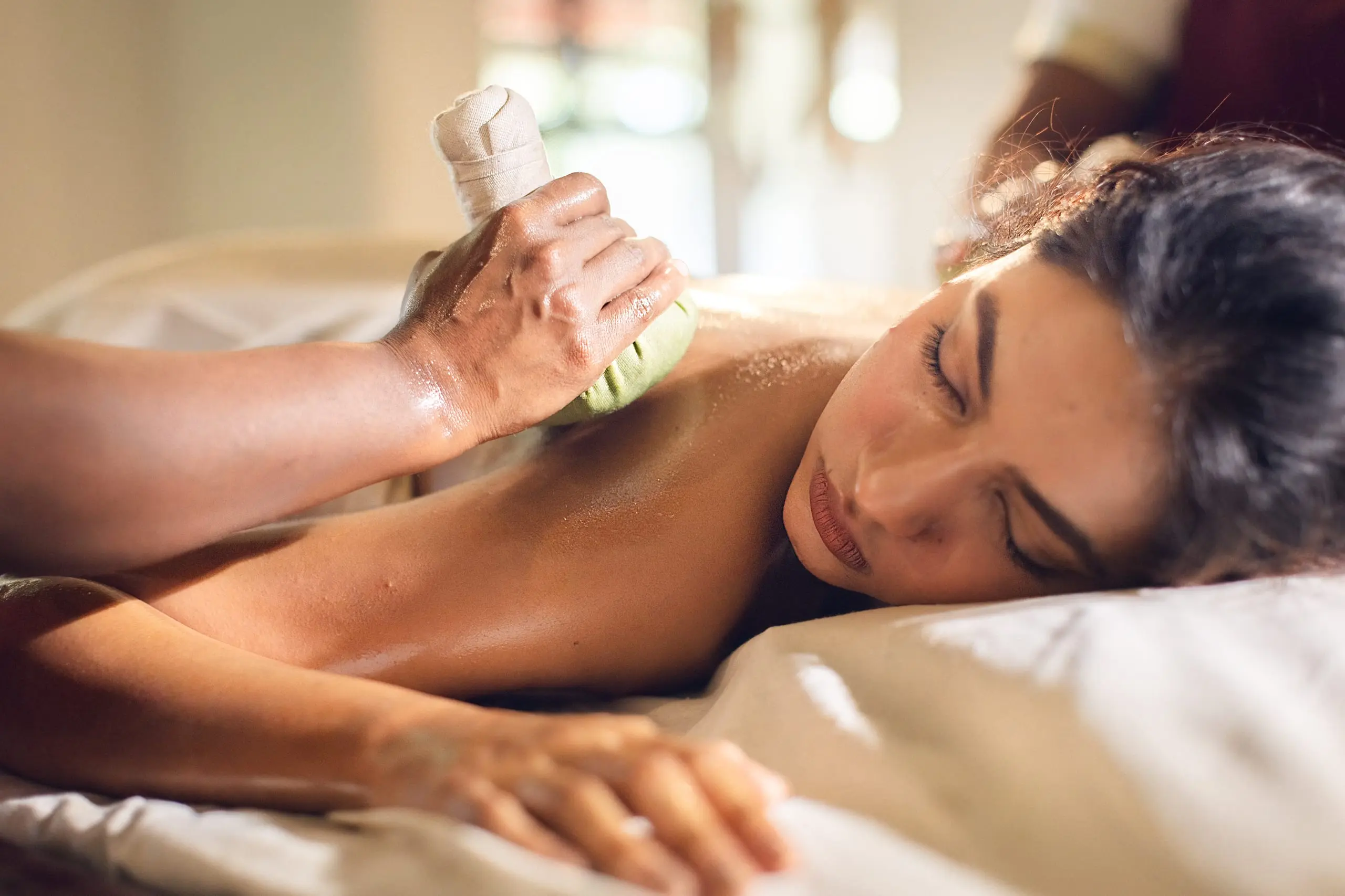 A warm herbal poultice pressed to the shoulder of a guest at rest.