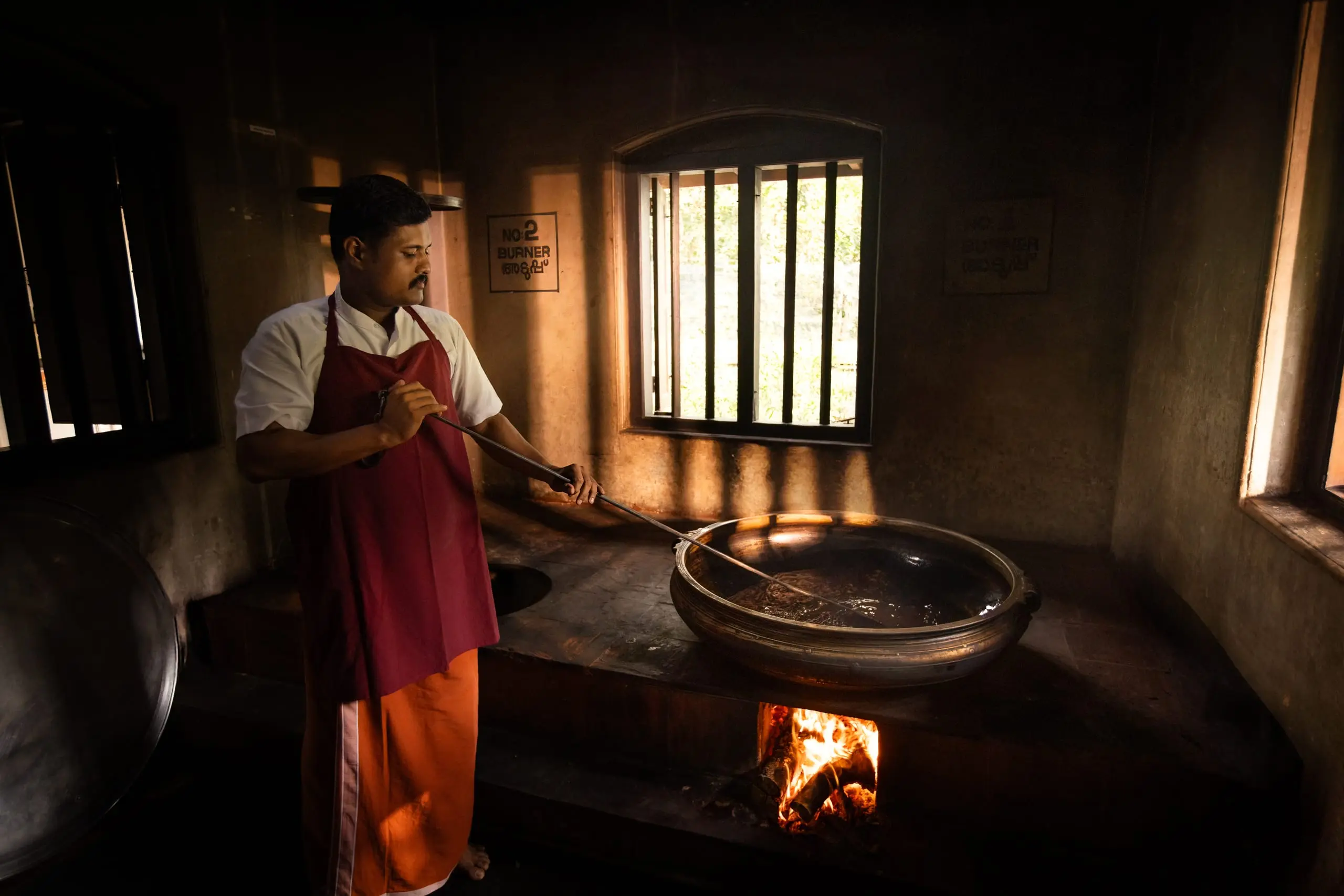 Oil prepared the old way: a wide vessel stirred slowly over a wood fire.