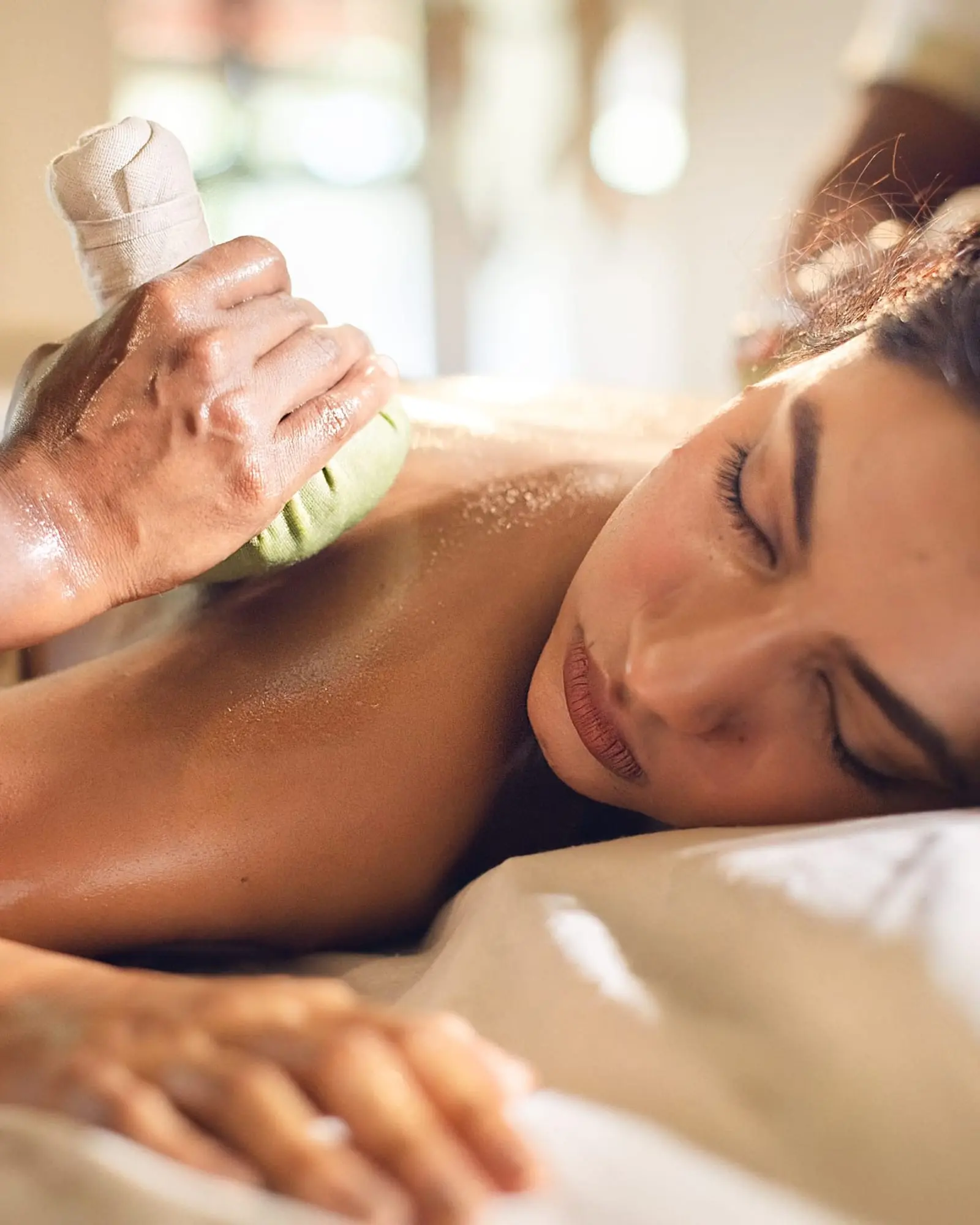 A warm herbal poultice pressed to the shoulder of a guest at rest.
